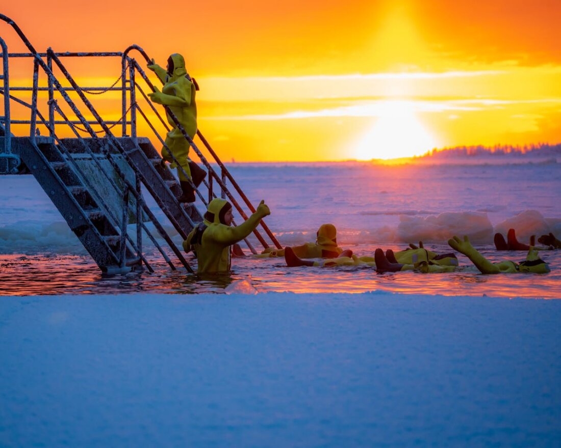 Eisbaden bei Sonnenaufgang: Gruppe schwimmt in eiskaltem Wasser