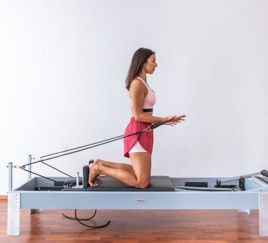 Frau beim Reformer Pilates Training im Studio