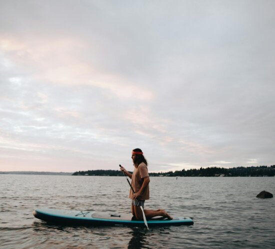 Person beim Stand-Up-Paddling auf ruhigem See — SUP 2023