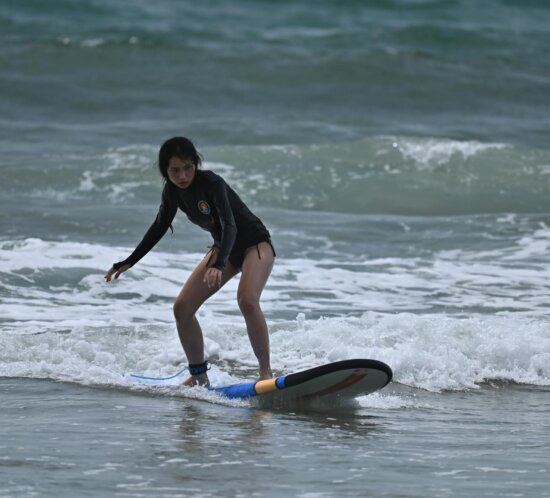 Surfer auf Anfänger-Welle beim Lernen