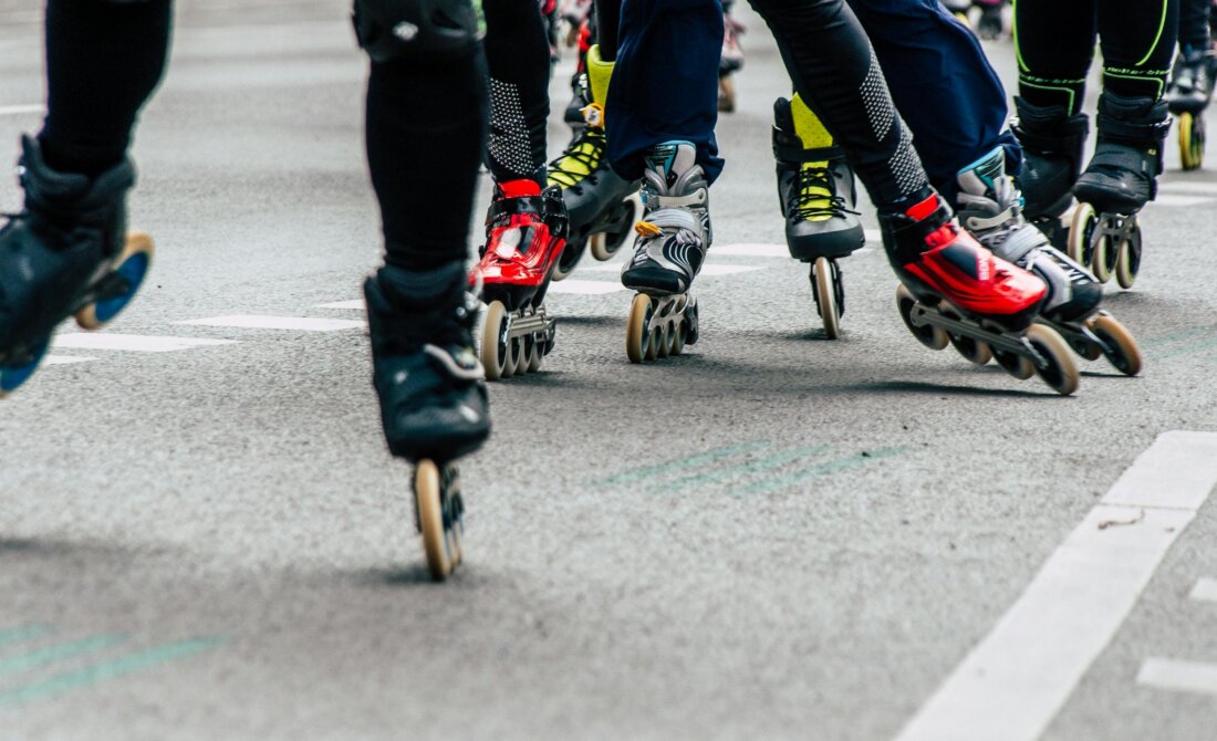 Gruppe von Inline-Skatern beim dynamischen Rollerblading auf einer urbanen Straße