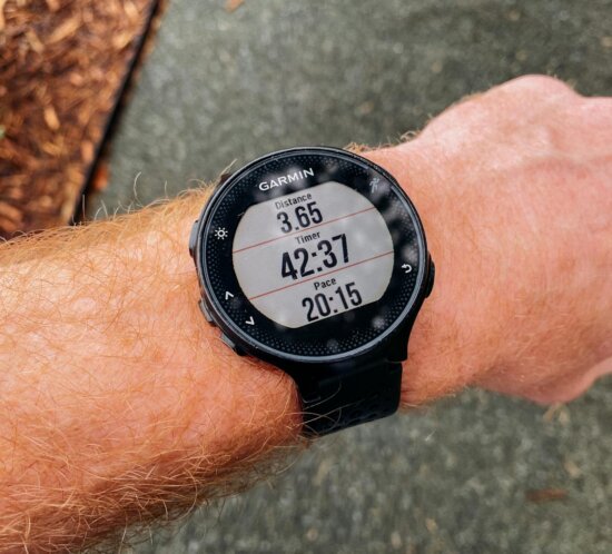 Smartwatch am Handgelenk zeigt Laufdaten beim Outdoor-Training