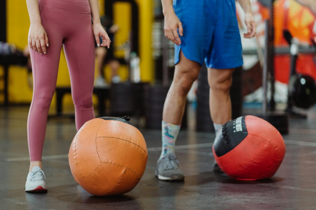 Zwei Athleten trainieren gemeinsam mit Medizinbällen, Doubles-Partner-Workout im Studio