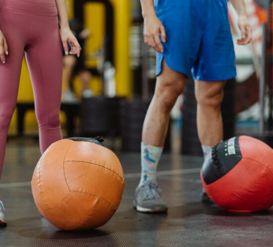 Zwei Athleten trainieren gemeinsam mit Medizinbällen, Doubles-Partner-Workout im Studio