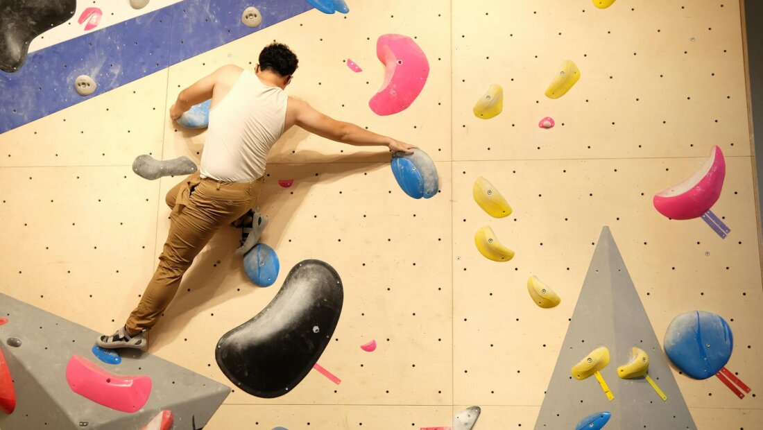 Person beim Bouldern an einer Indoor-Kletterwand