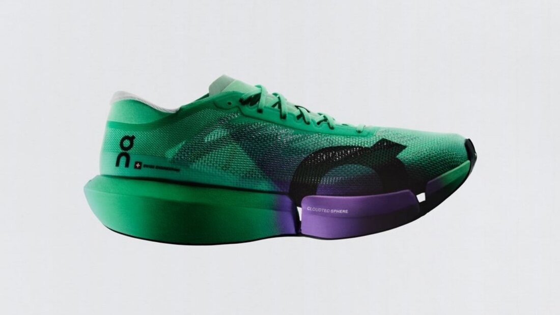 Grün-schwarzer On-Laufschuh mit violetten Elementen in seitlicher Ansicht vor weißem Hintergrund.